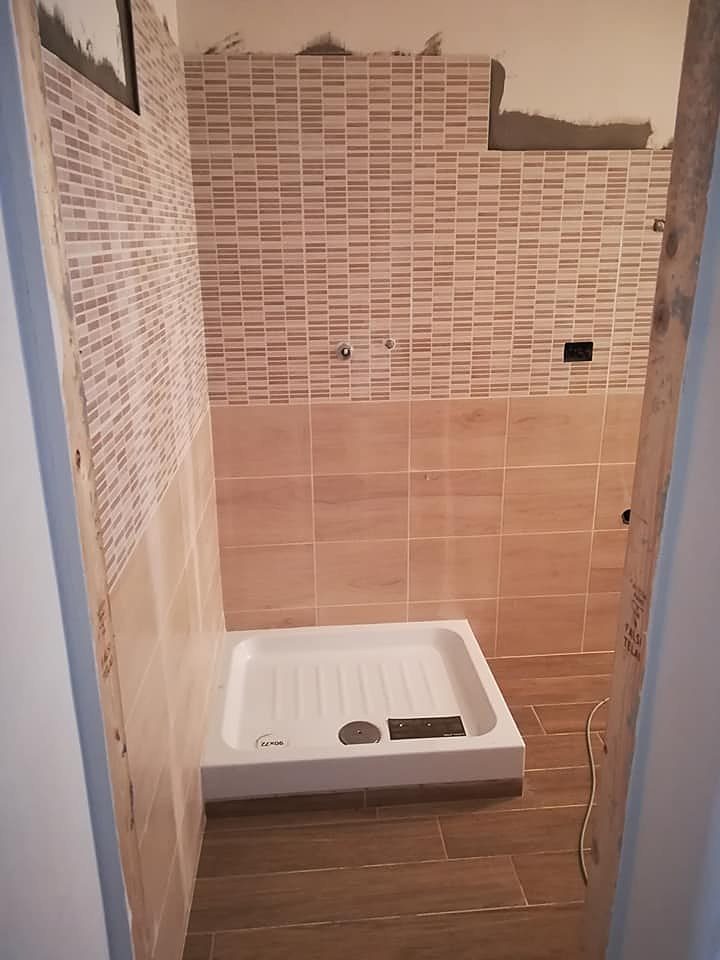 Lo stesso bagno rivestito in gres effetto legno, con il piatto doccia